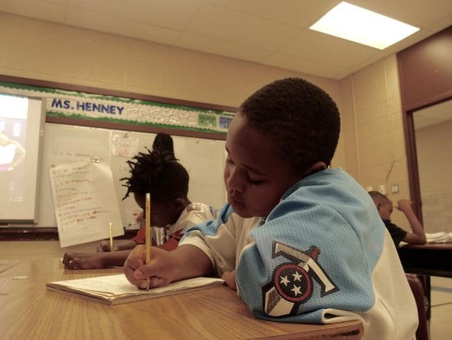 Third-grader Brieston Fleming, 8, writes a story about his favorite athlete, Dwayne Johnson, after reading several books about sports stars during the last week of the state-funded Read to be Ready literacy camp at Cornerstone Prep in Memphis' Frayser neighborhood. June 27, 2019.